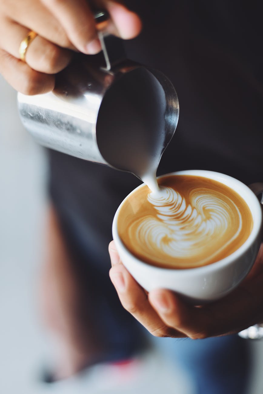 Barista gießt Milch für Latte Art